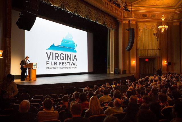 Virginia Film Festival screen with speaker on stage. Audience in foreground.