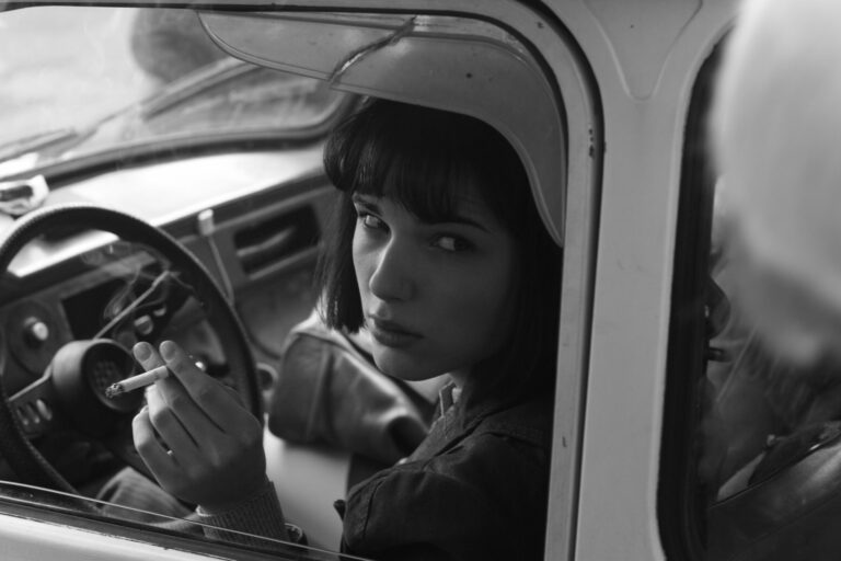 Woman in vintage car smoking cigarette, film series