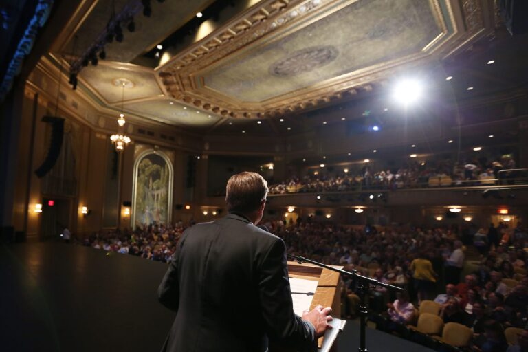 Speaker addressing a large audience at the 2017 VFF event on stage.
