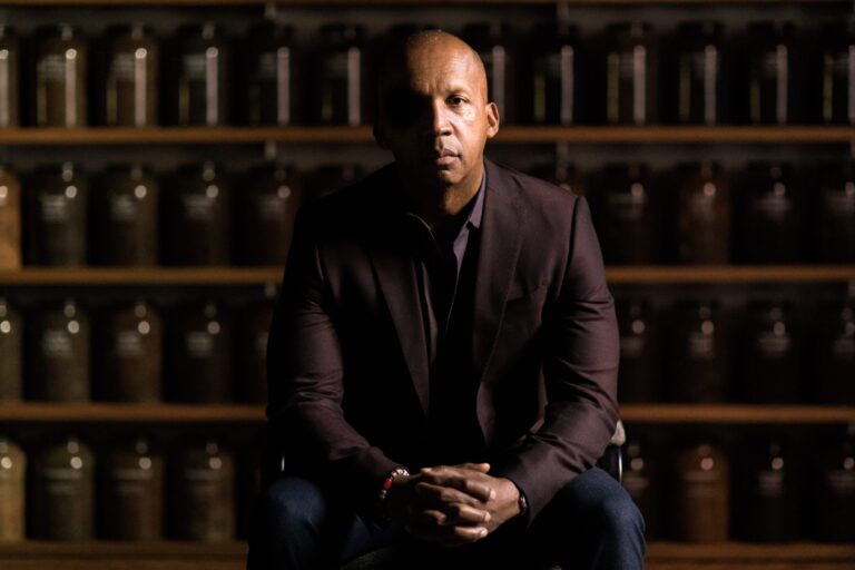 Bryan Stevenson, subject of True Justice documentary, sits in front of shelves of jars.