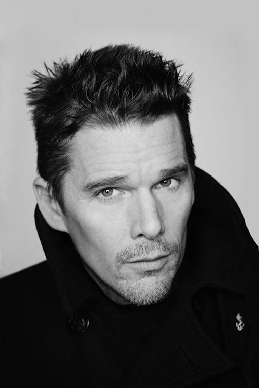 Black and white portrait of actor Ethan Hawke wearing a dark coat.
