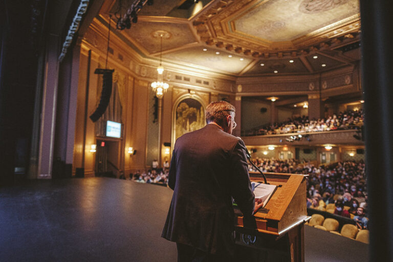 Man speaking at podium in ornate theater at the 2022 Virginia Film Festival.