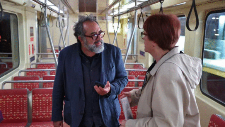 Eugenio Caballero, production designer, talking on a subway car.