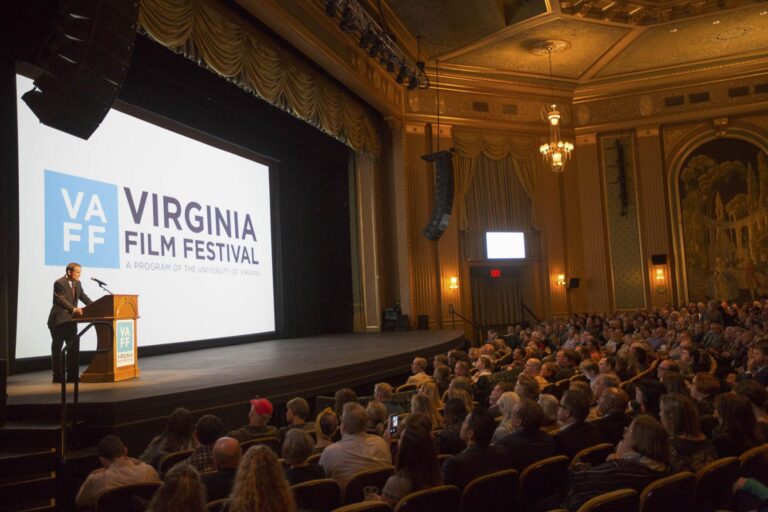 Virginia Film Festival event: speaker on stage, crowd in ornate theater. VA FF logo visible.