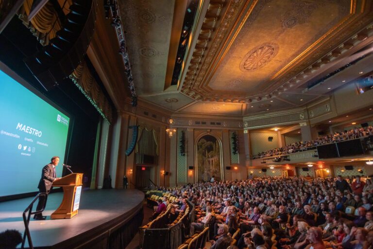 Speaker at the 2024 VAFF festival addressing a large audience in a grand theater.