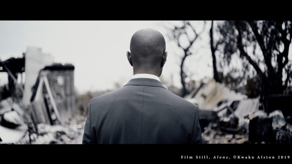 Man in suit looks at ruins. Film Still, Alone, Kwaku Alston 2019