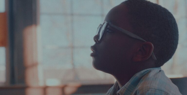 Young boy wearing glasses looks up, perhaps inspired 'For the Moon'.