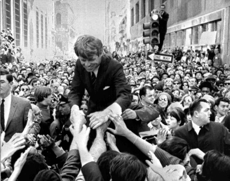 Robert Kennedy surrounded by supporters in 1968. "One Way" sign visible.