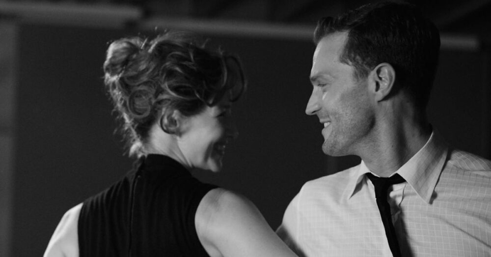 Black and white image of a smiling couple looking at each other.