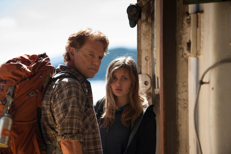 Man and teenage girl in "Wildlike" movie scene. Father and daughter in a serious moment, looking concerned.