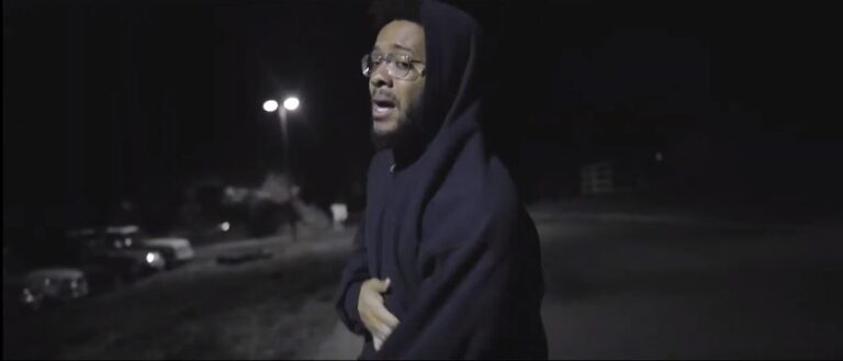 Man in hoodie rapping in 9 Pillars Hip Hop Music Video