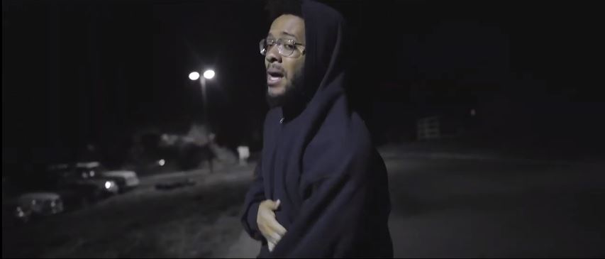 Man in hoodie rapping in 9 Pillars Hip Hop Music Video