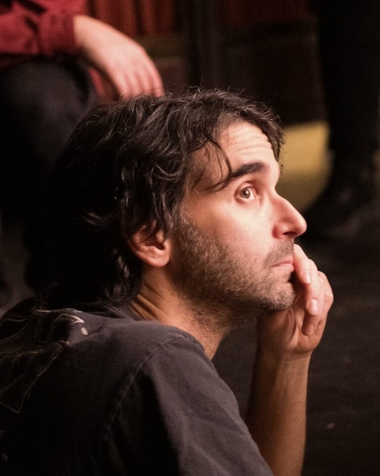 Alex Ross Perry in profile, looking up with hand to chin.
