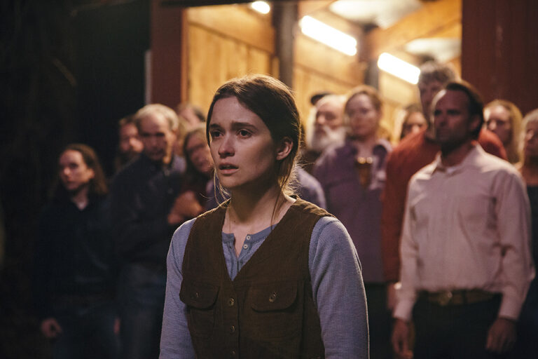 Appalachian woman surrounded by her community, looking concerned. Scene from "Them That Follow.