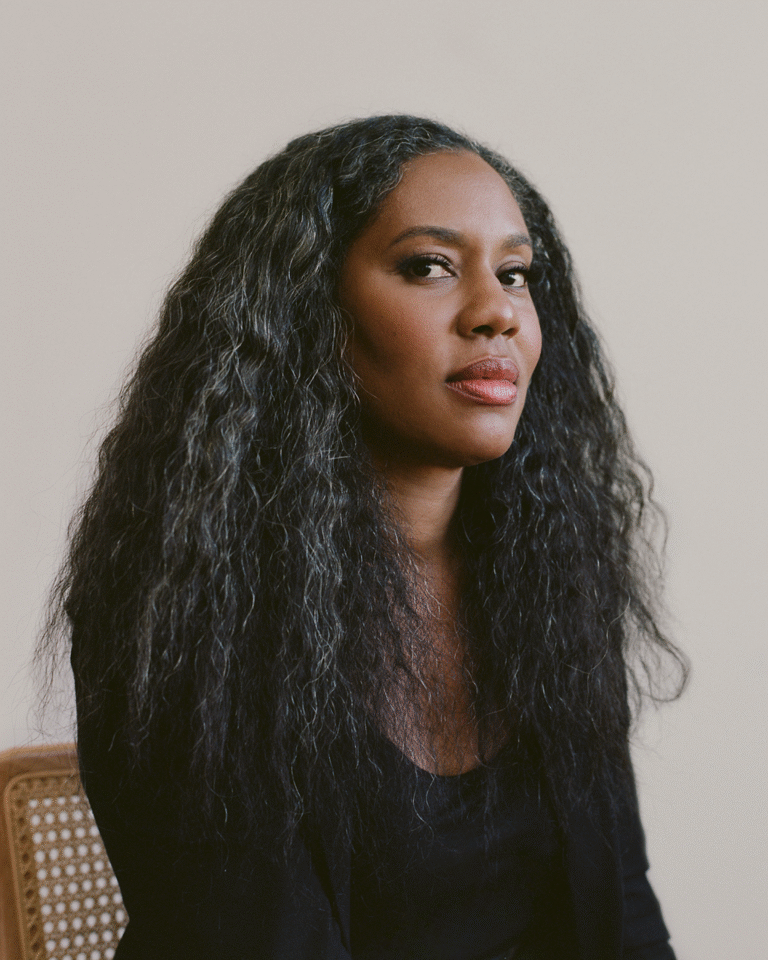 Portrait of Alisa Payne with long, flowing graying hair, wearing a black top.