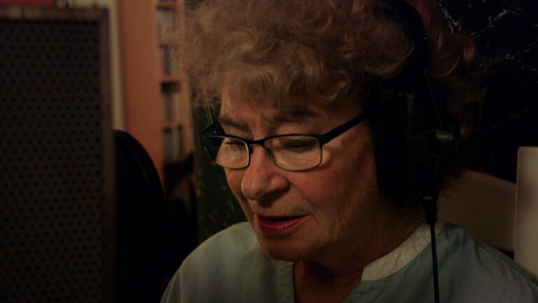 Shirley Collins in recording studio with headphones and glasses