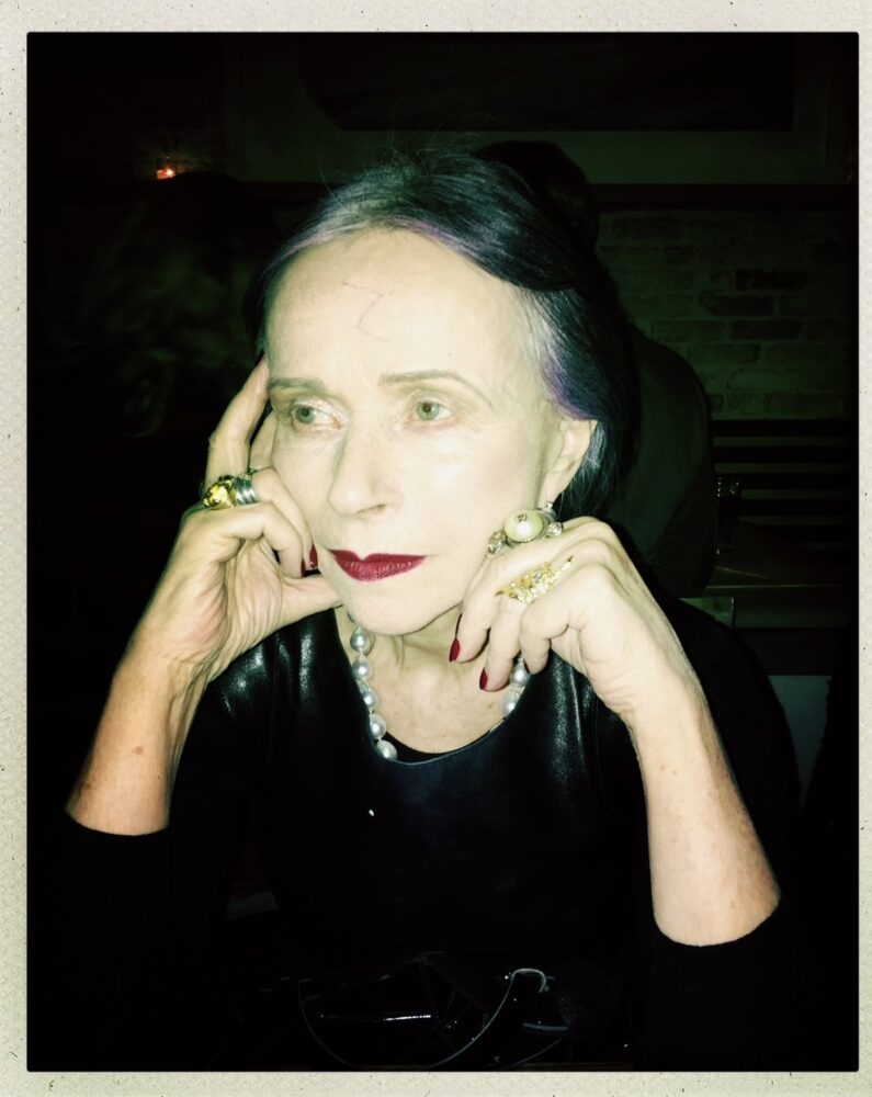 Beatrix Ost portrait with dark lipstick and striking jewelry.