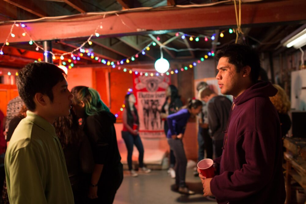 People at a party with colorful lights, possibly a film event at Mason.