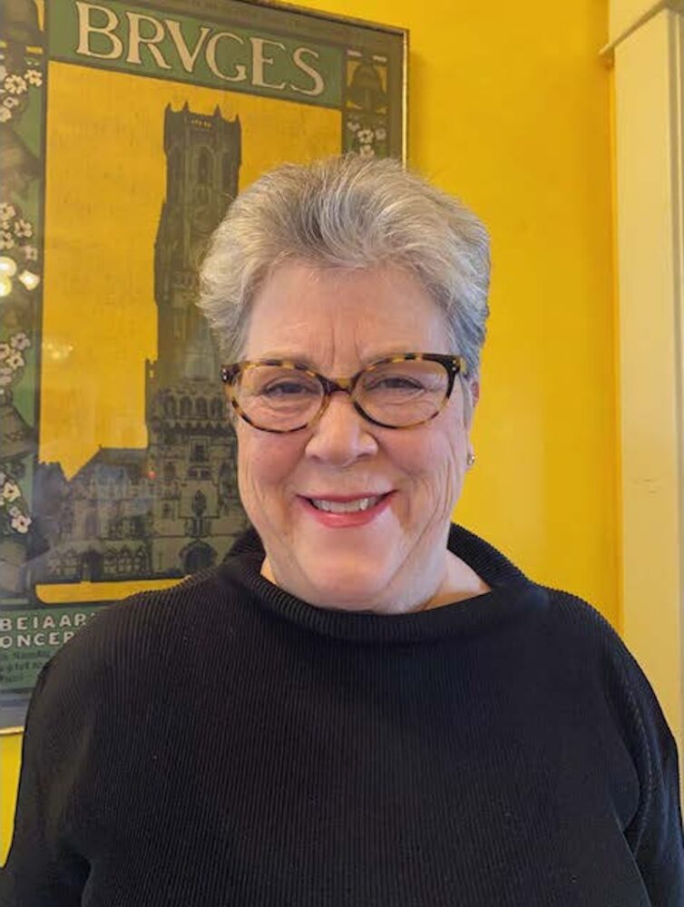 Portrait of Elizabeth Turner with short gray hair and glasses, smiling.