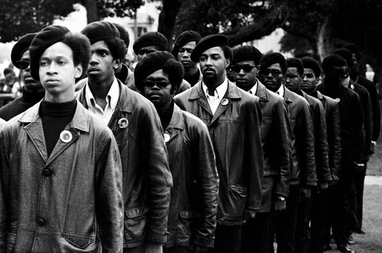 Black Panthers in formation wearing berets and leather jackets.