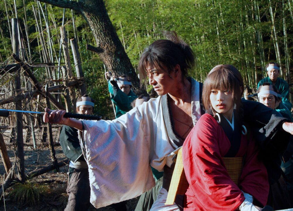 Blade of the Immortal scene: Manji protects Rin from attackers in a forest.