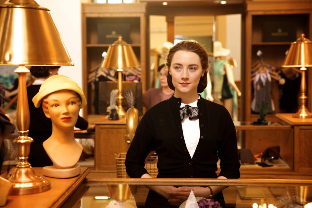 Saoirse Ronan as Eilis in "Brooklyn" behind a shop counter.