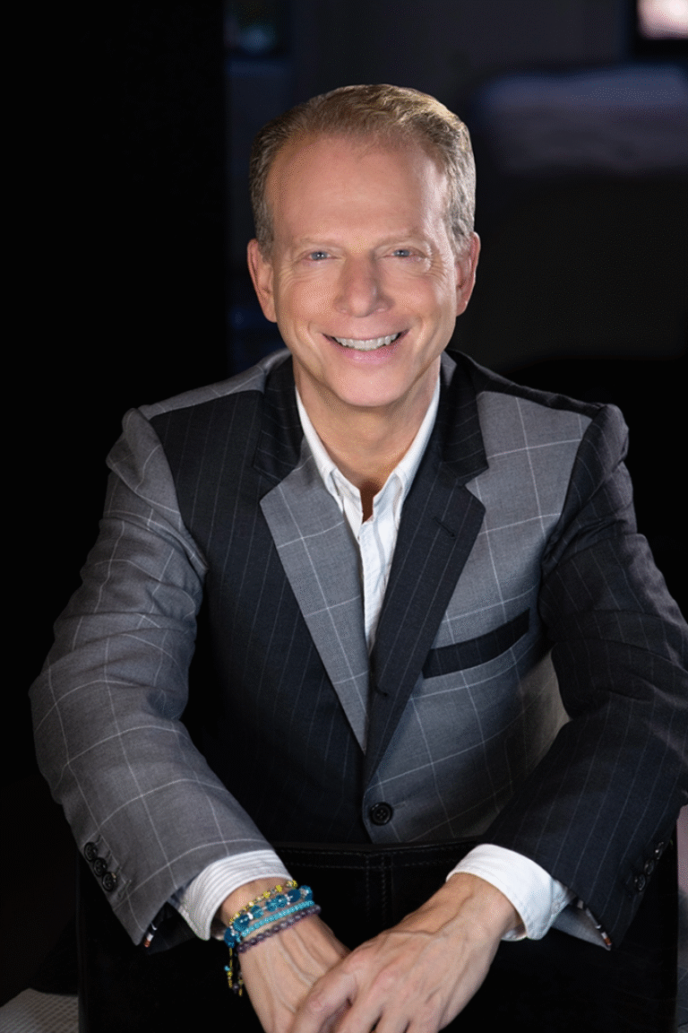 Bruce Cohen smiles in a gray and black suit.