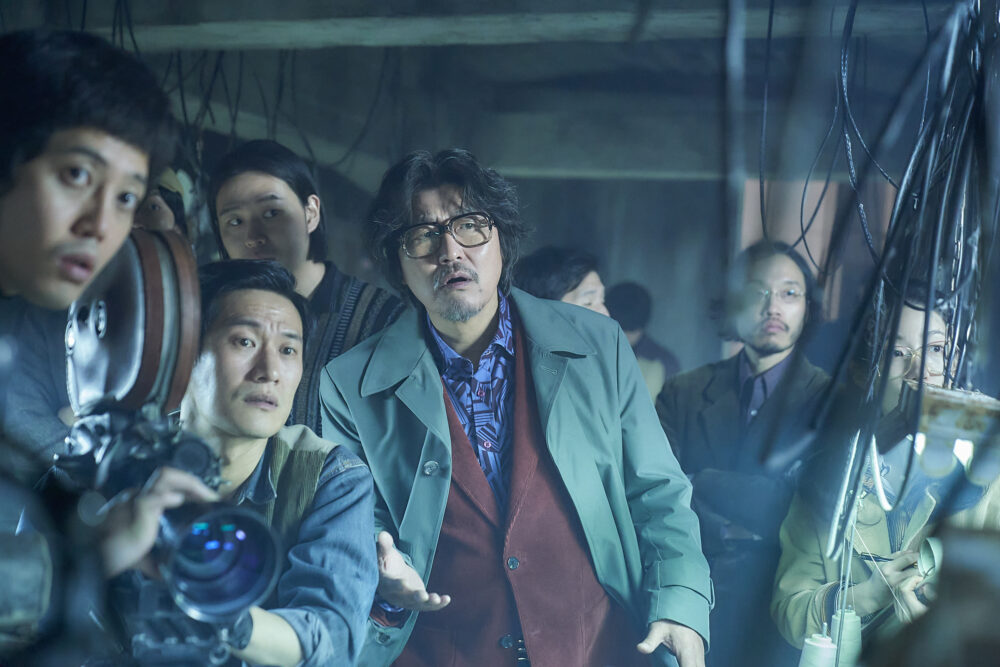 Actor Song Kang-ho in "Cobweb" surrounded by film crew.