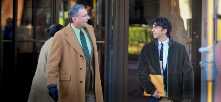 Two men in coats walking outside wearing gloves and jackets.