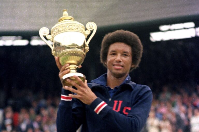 Arthur Ashe holding the Wimbledon trophy, wearing a USA jacket, celebrating his historic win.