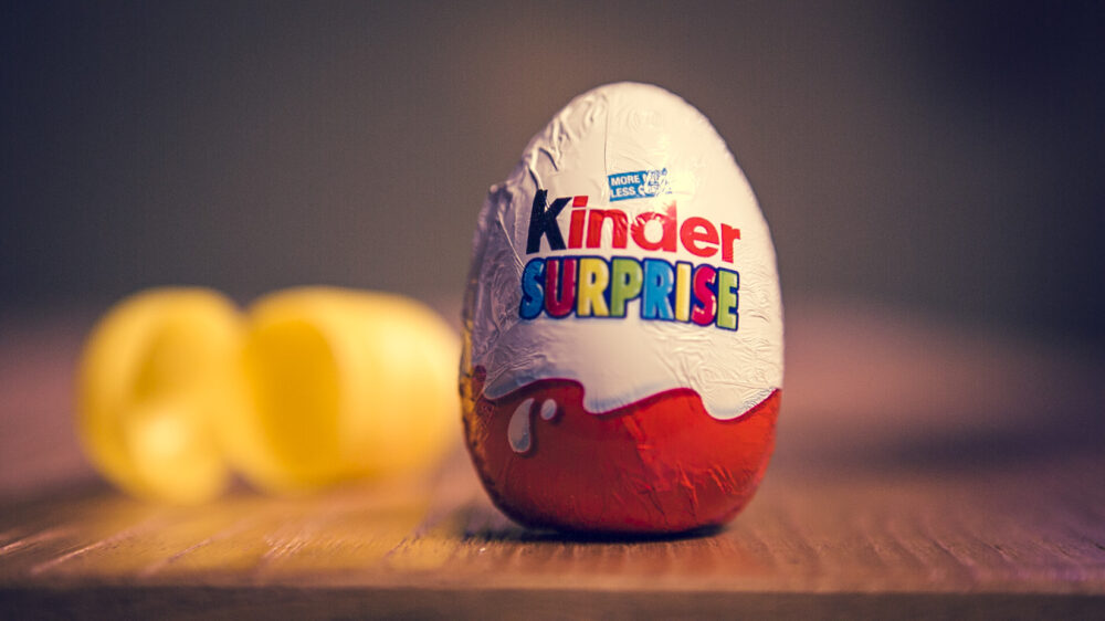 Kinder Surprise egg with a yellow plastic toy capsule, showcasing a popular "Crooked Candy" treat.
