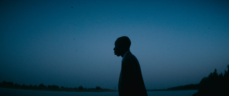 Silhouette of a man against a dark blue sky, possibly related to "Demba.