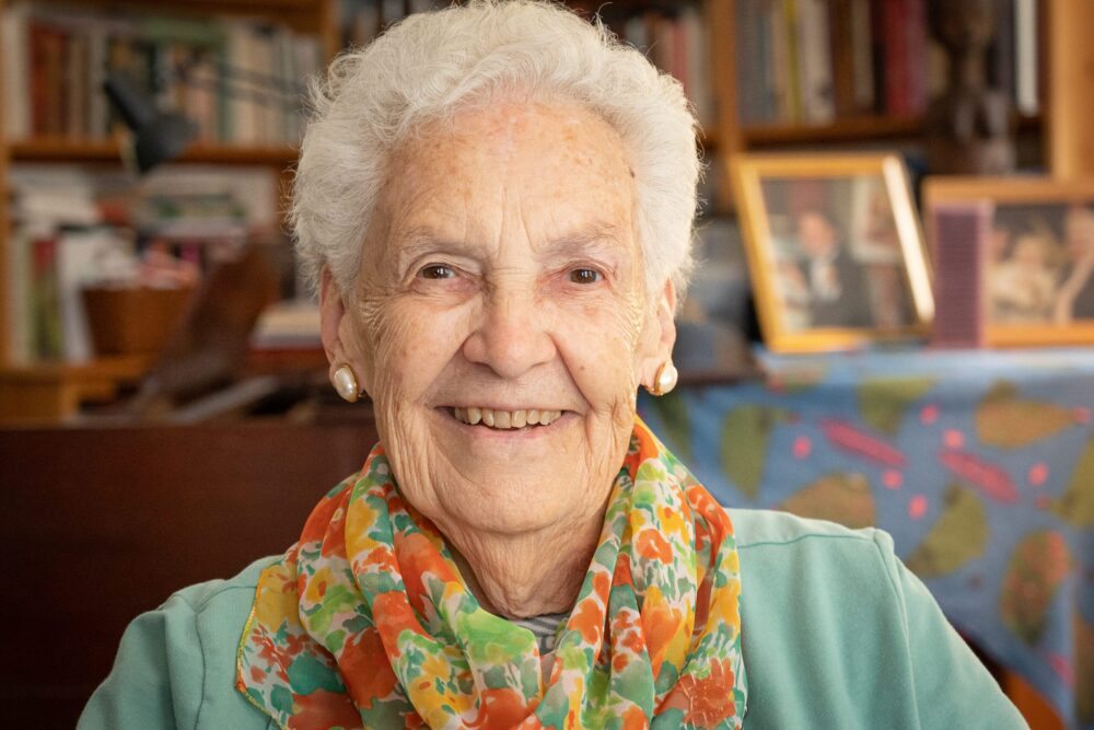 Smiling older woman, Alice, with white hair and colorful scarf