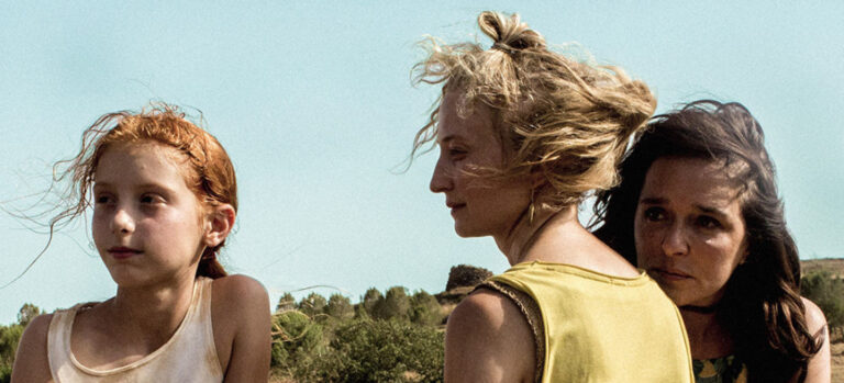 Three women stand together in a sunlit field. "Daughter of Mine" movie image.