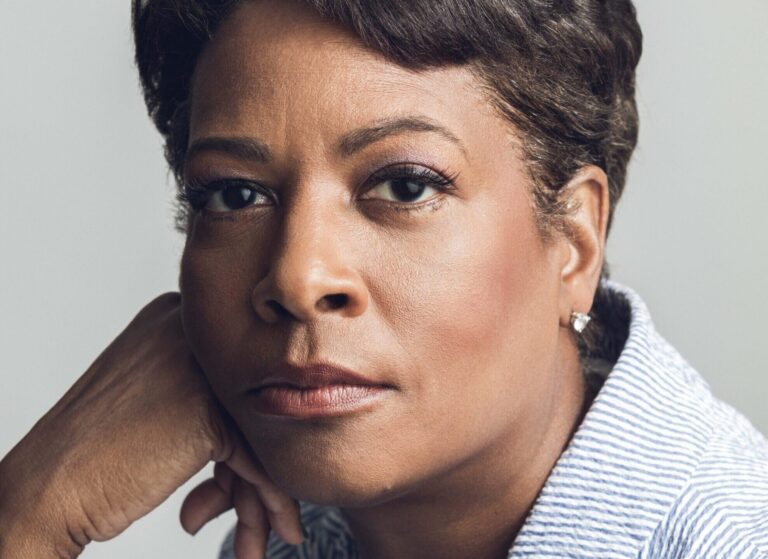 Close-up portrait of Dawn Porter, wearing a striped shirt and a thoughtful expression.