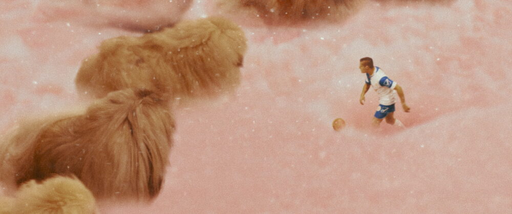 Diamantino movie scene: Soccer player on a surreal pink field.