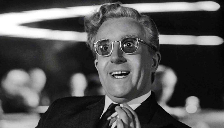 Dr. Strangelove, portrayed by Peter Sellers, smiles with glasses and a suit.