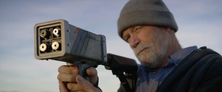 Man holding a futuristic device, possibly for an "Eco-Hack!" project.