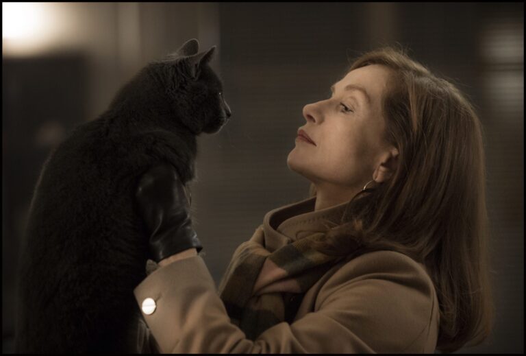 Isabelle Huppert in "Elle" holds a gray cat wearing a leather glove.