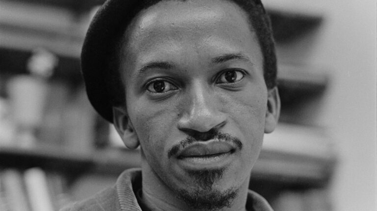 Close-up portrait of Ernest Cole, wearing a beret, looking directly at the camera.