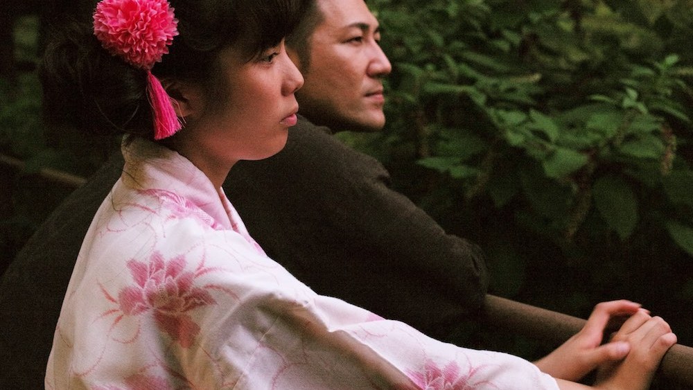 Woman in yukata and man looking pensively in "Family Romance, Llc" film still.