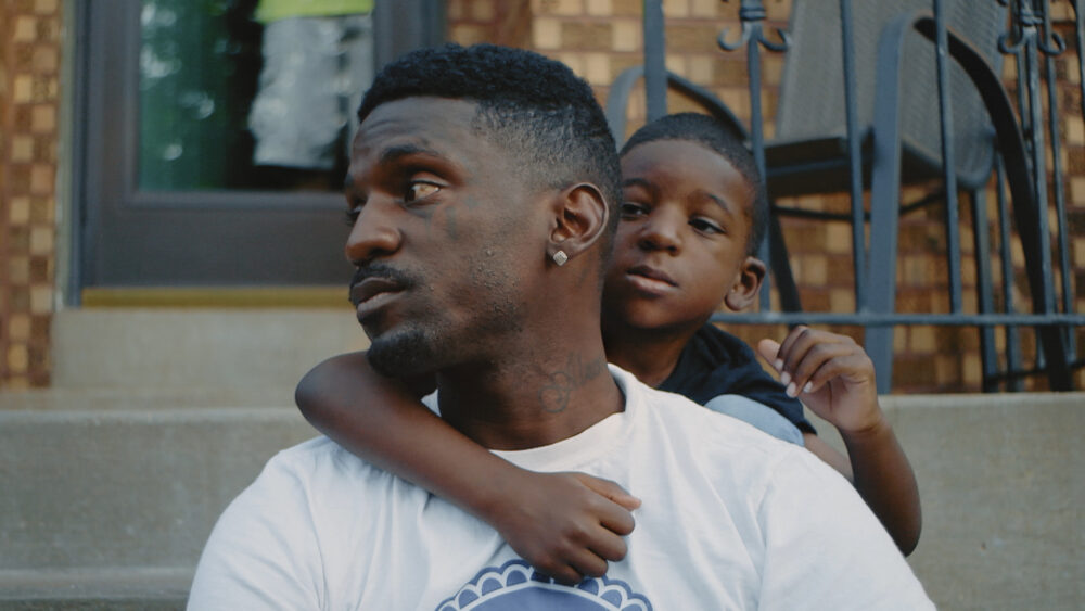 Father and son embrace on porch steps.