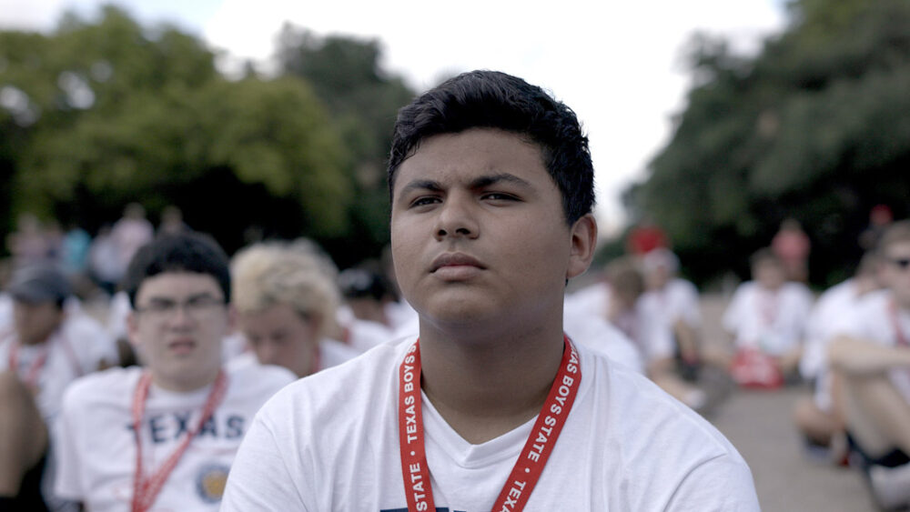Teenager at Texas Boys State event wearing a white t-shirt.