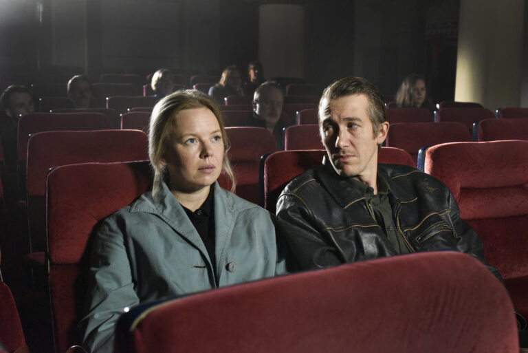Couple watching a movie in a theater, evoking the mood of "Fallen Leaves.