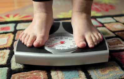 Feet on a scale, showing a weight reading..
