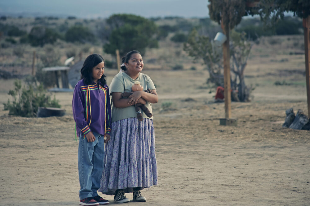 Two Indigenous youths in Frybread Face and Me, standing outdoors in a rural setting.