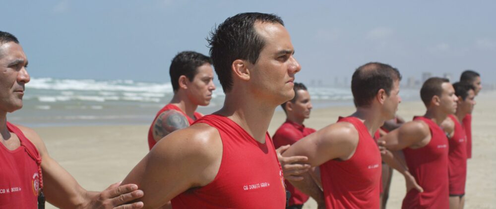 Lifeguards in red shirts stand on Futuro Beach.