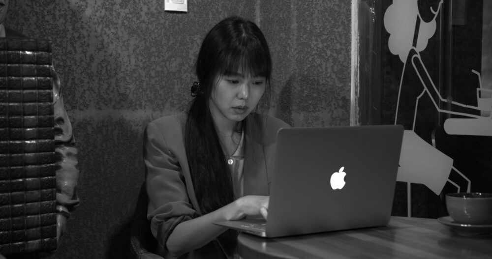 Woman working on a laptop at a table.