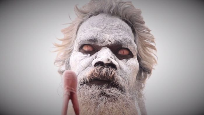 Man with white face paint and beard, possibly Galka ritual.
