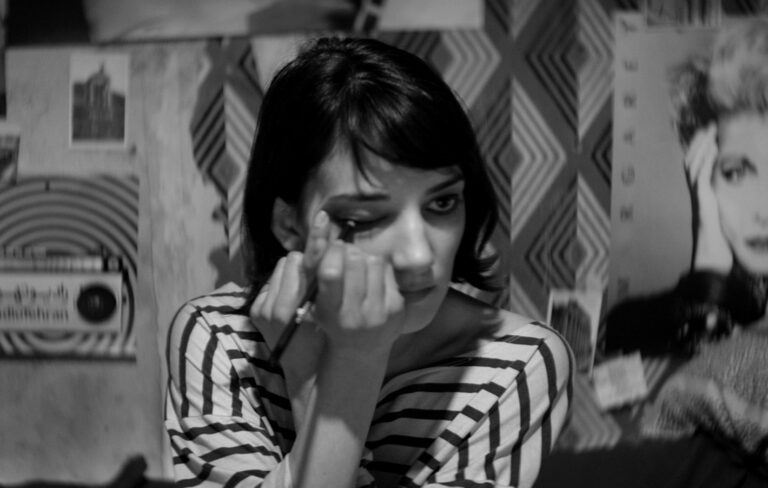 Girl applies eyeliner in black and white.